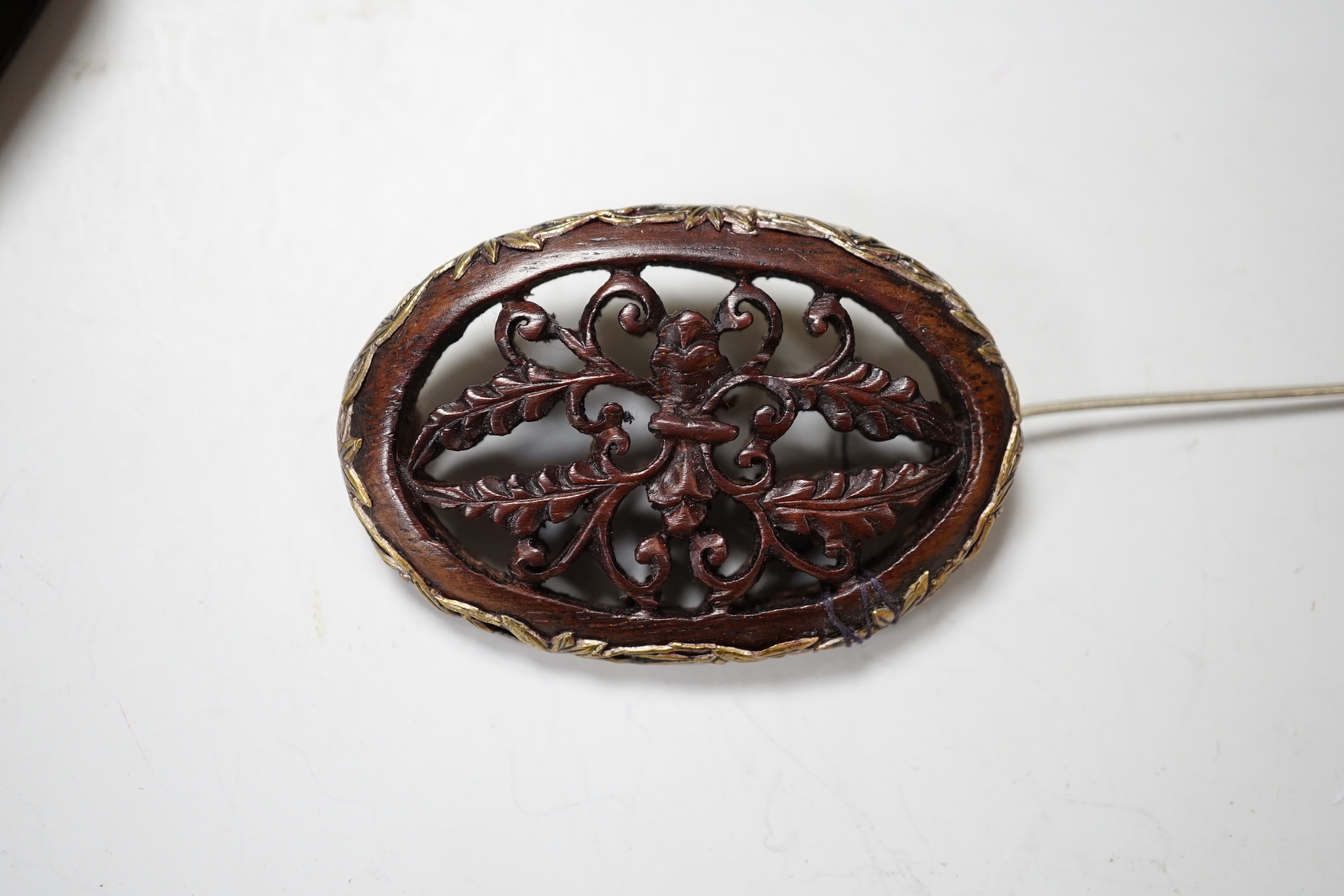 A Chinese chalcedony brooch, a Chinese carved wood brooch, a damascened steel clip and a Japanese trade reference book